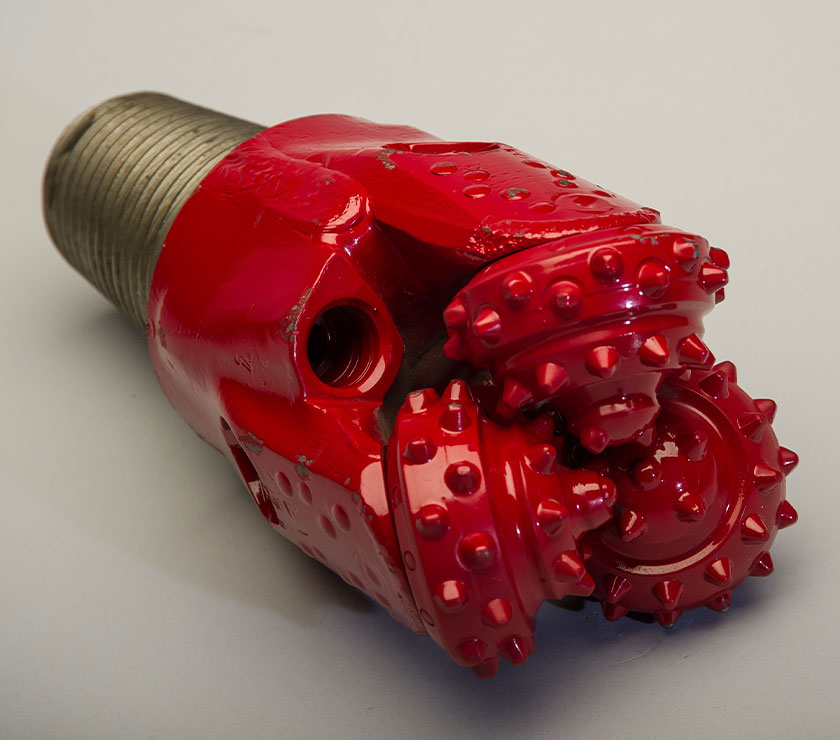 Red tricone rock drill bit with tungsten carbide insert cutters