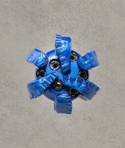 Top view of blue PDC drill bit with multiple cutting blades and polycrystalline diamond cutters.
