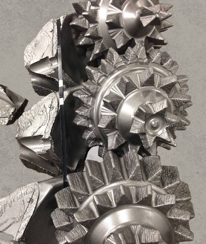 Cutaway view of tricone rock drill bit showing internal gear and cutter structure.