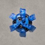 Top view of blue PDC drill bit with multiple cutting blades and polycrystalline diamond cutters.