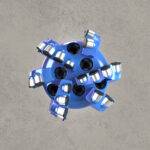 Top view of blue PDC drill bit with multiple polycrystalline diamond cutters.